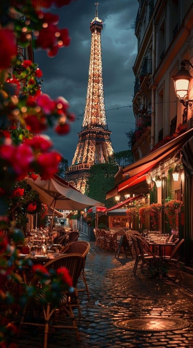Cozy Paris street cafe with view of the Eiffel Tower at night.